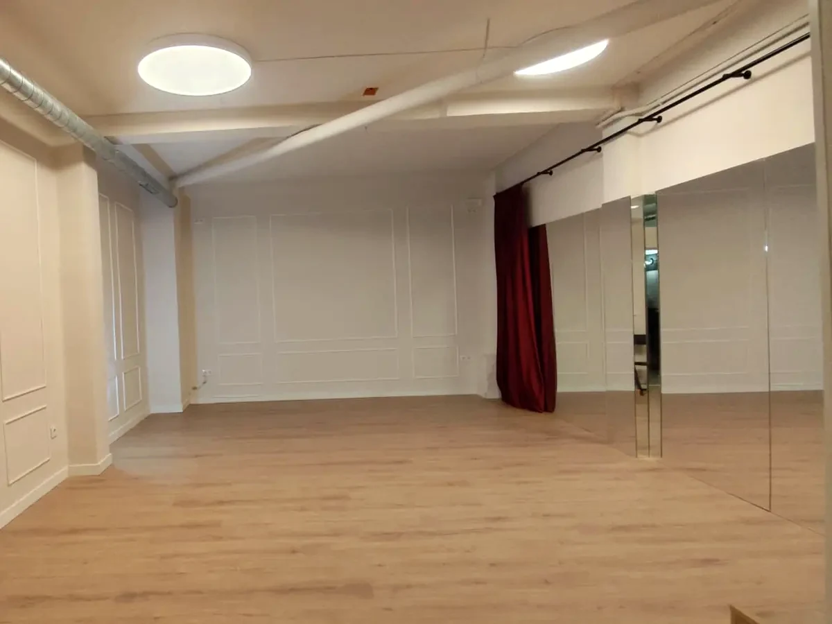 Sala principal de Boa Negra con suelo de madera, espejo y cortina roja